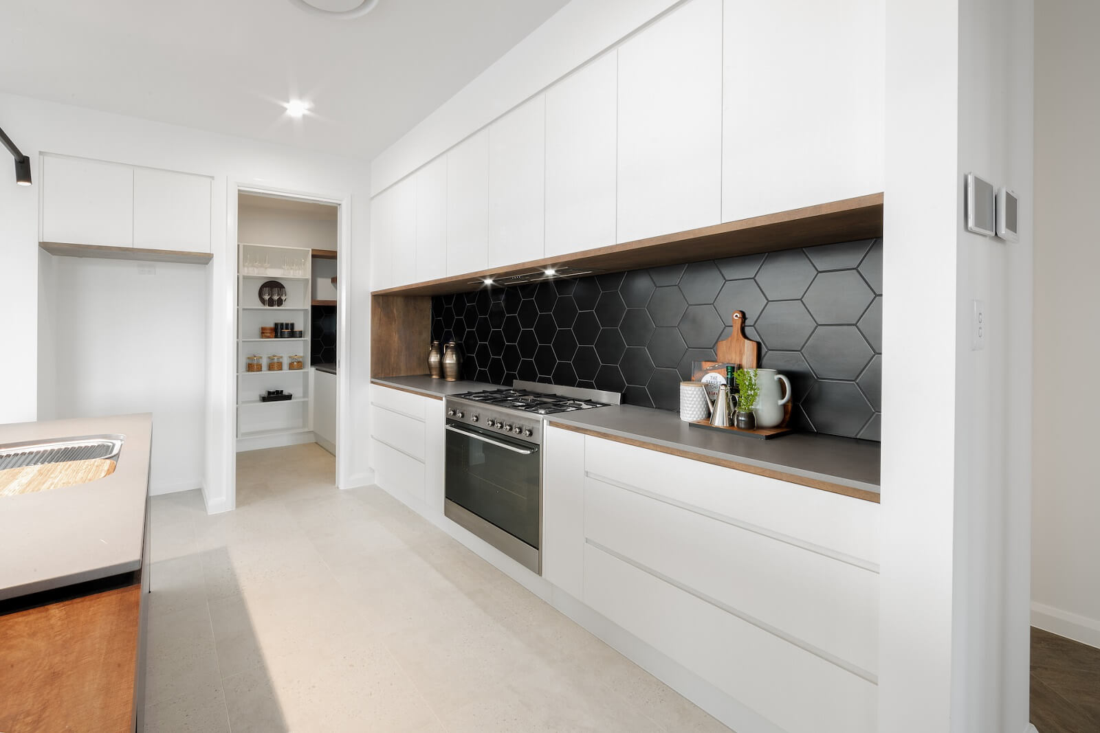 contemporary kitchen renovation with honeycomb black splash back and white cabinets