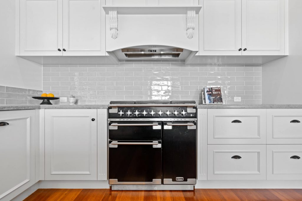 Marine Drive East kitchen renovation featuring modern black stove and stunning white cabinets