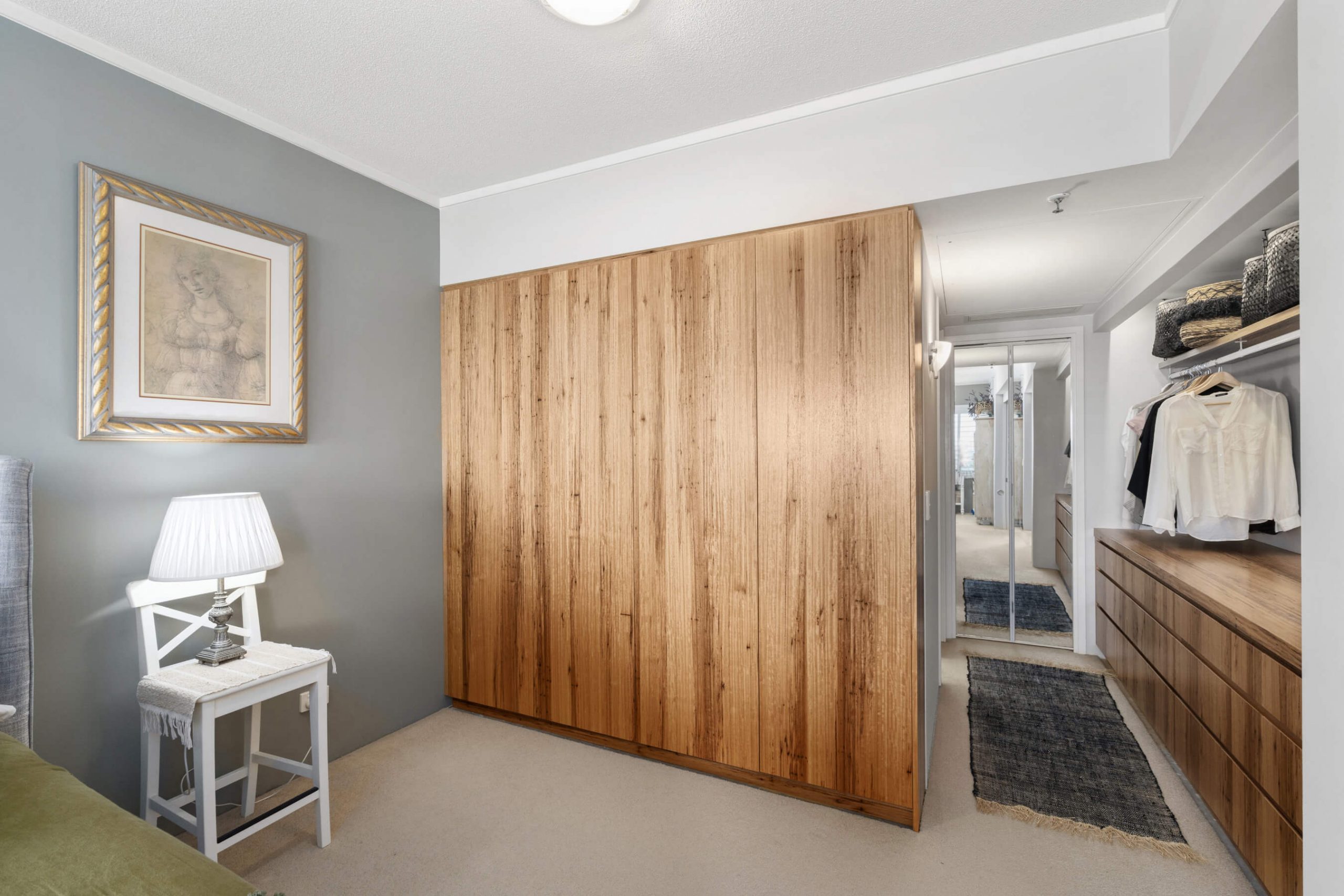 wooden wardrobe and a lamp on the nightstand in gold coast custom wardrobe renovation