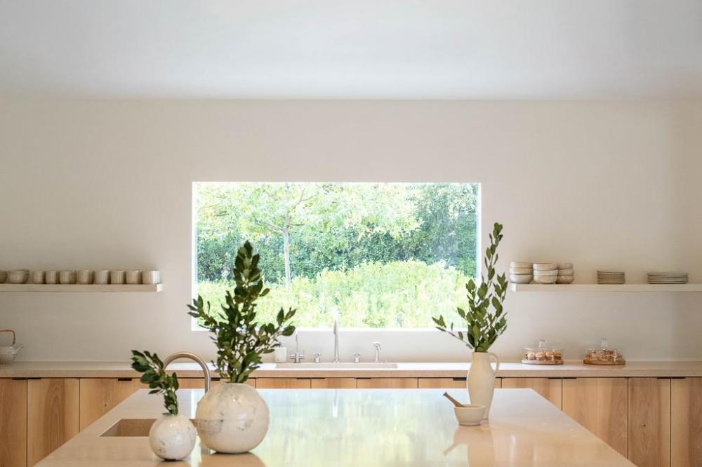 Kim k new mansion kitchen renovation in her home shot from the kitchen island looking out the kitchen window